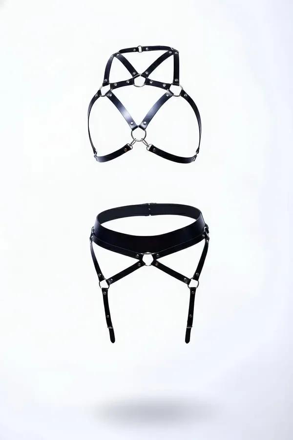black faux leather harness bra and garter belt set with silver O-rings and X-cross strap design on white background