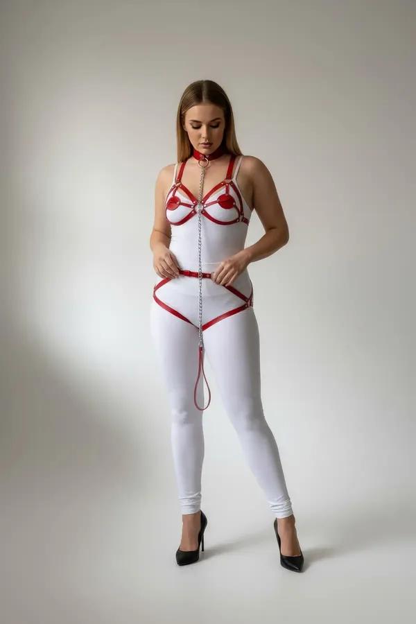 red faux leather body harness with silver chain detail and garter straps worn over white bodysuit, plus-size model
