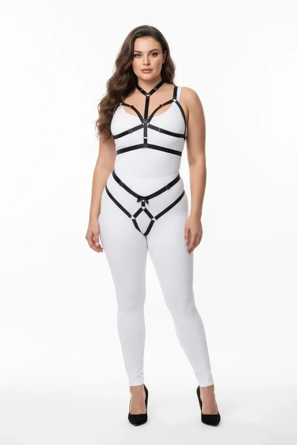 black vegan leather body harness and garter belt set with silver O-rings worn over white leggings, plus size model