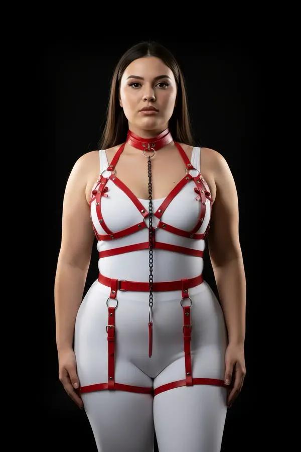 Red faux leather full body harness set with chest cage straps, front chain drop, waist belt, and adjustable thigh garters on 
