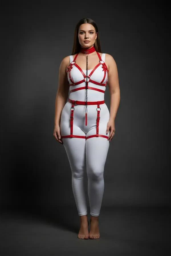 Red faux leather full body harness set with chest cage straps, front chain drop, waist belt, and adjustable thigh garters on 