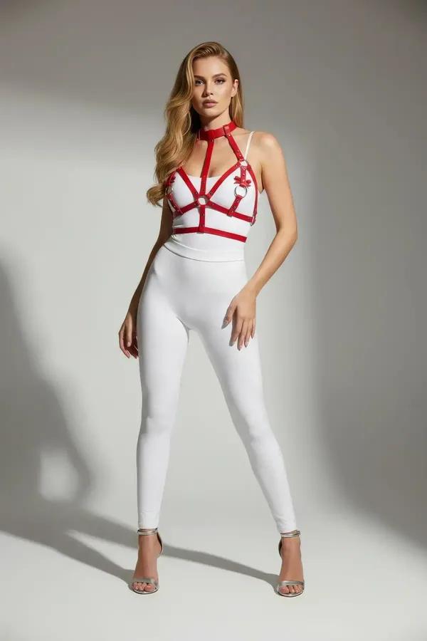 Red faux leather chest harness with high neck collar and silver O-rings worn over white bodysuit
