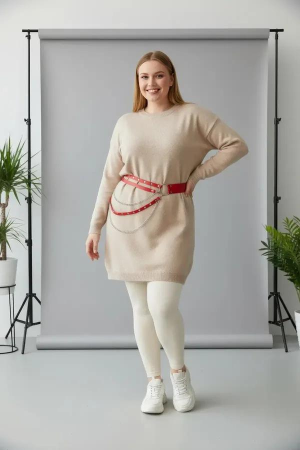 red faux leather waist harness belt with three draped silver chains worn over cream sweater and light blue jeans