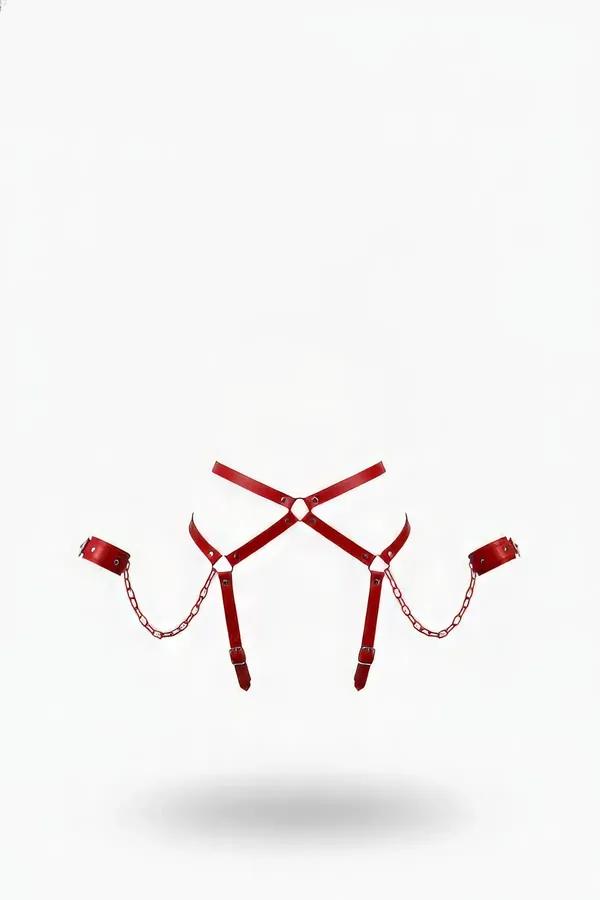 red faux leather waist harness with X-cross strap design silver link chains and matching red wrist cuffs on white background