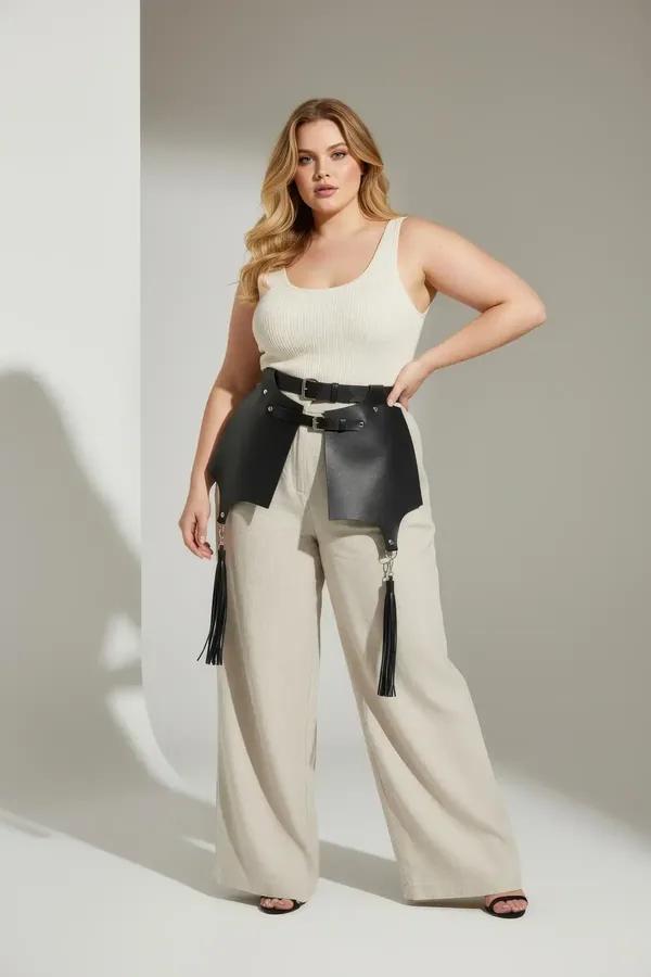 black faux leather waist harness with wide skirt panels and tassel fringe worn over white T-shirt and jeans