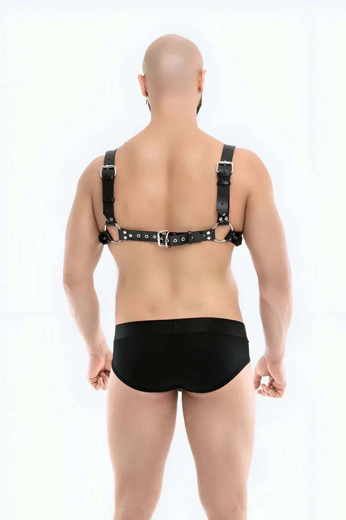 Flat lay of the Men's Adjustable Vegan Leather Chest Harness with Chain Detail in matte black
