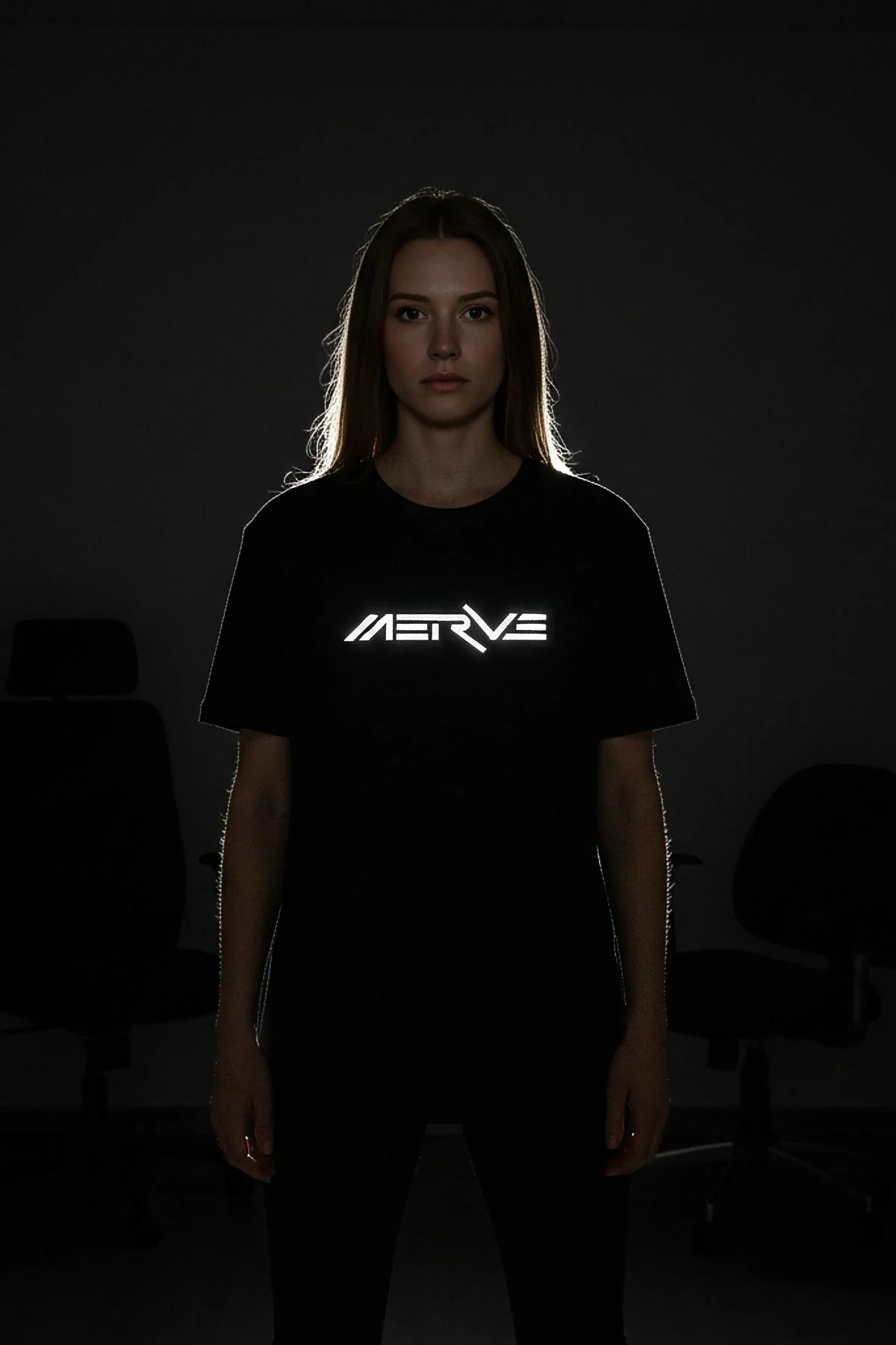 black reflective graphic tee custom print glowing under direct light in dark setting