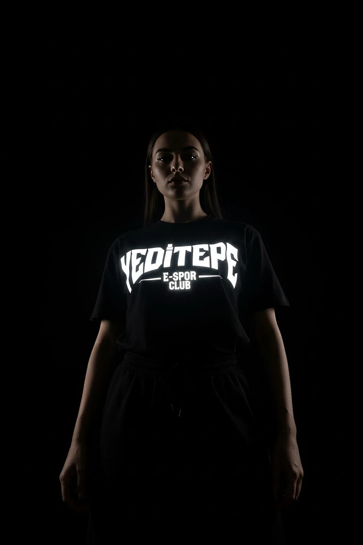 black reflective logo crop t-shirt with bold white block-letter chest graphic lit under direct light