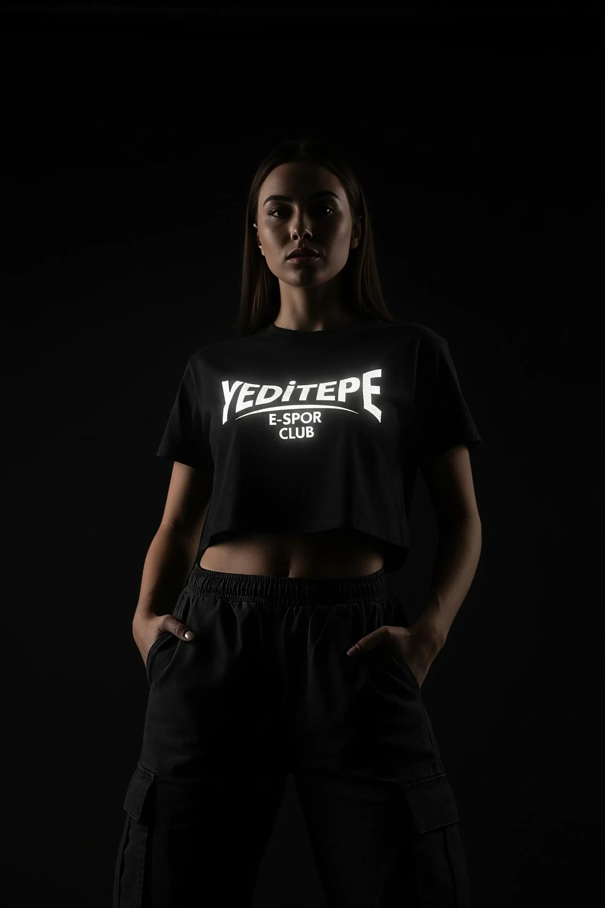 black reflective logo crop t-shirt with bold white block-letter chest graphic lit under direct light