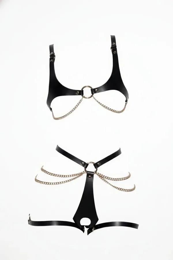 Faux leather harness bra and garter set in black featuring a cupless O-ring design and draped silver metal chains.
