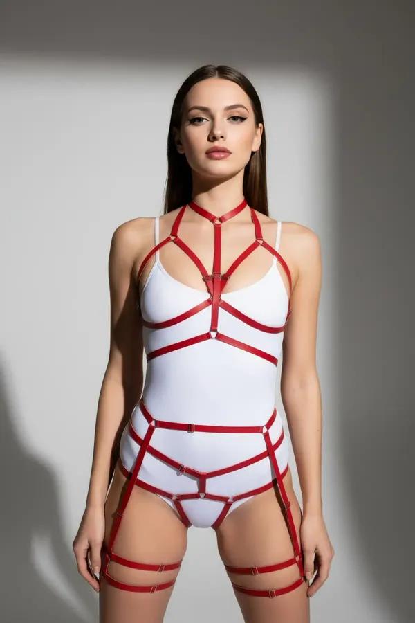 Red faux leather full body harness with gold O-rings and matching double-strap thigh garters worn over white bodysuit