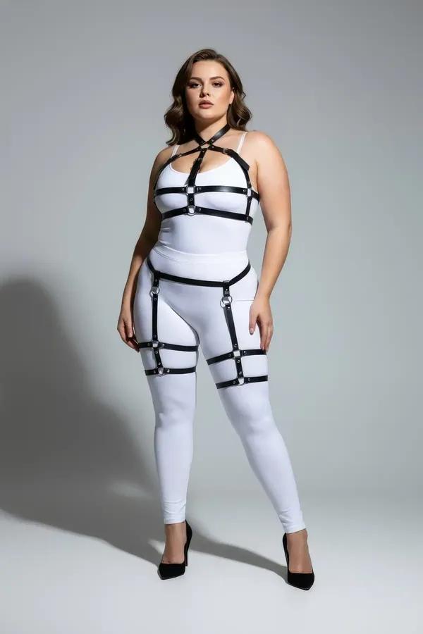 Black faux leather full body harness with garter straps, thigh bands, and silver O-ring hardware on plus-size model