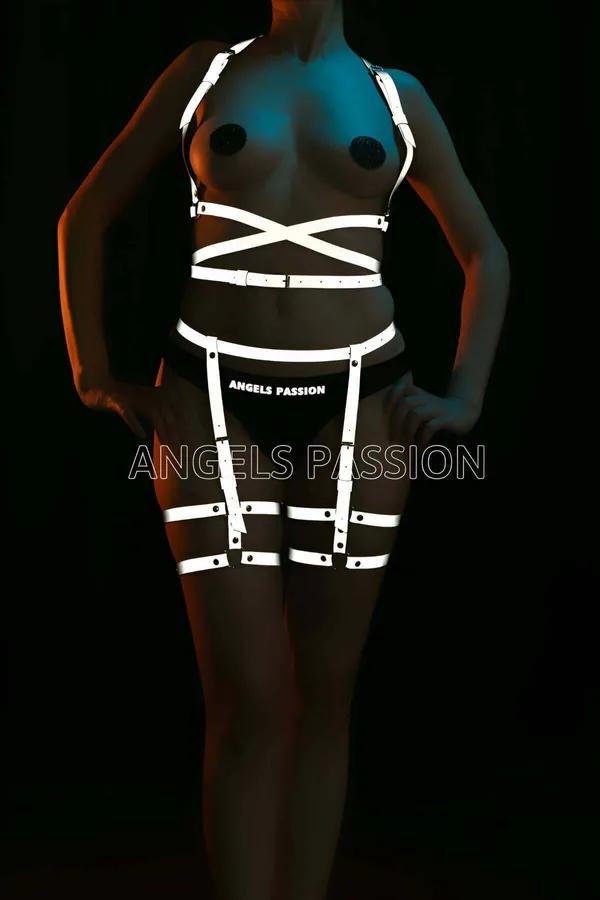Model wearing black Symmetrical Rainbow Reflective Body Harness Set glowing in a brilliant neon spectrum under direct camera flash front view