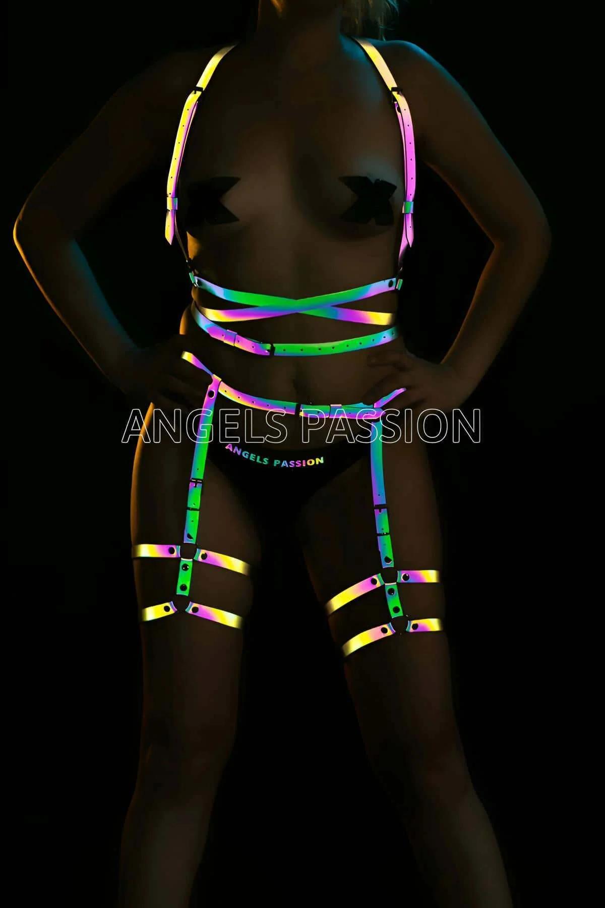 Model wearing black Rainbow Reflective Full Body Harness Set glowing in a brilliant neon spectrum under direct camera flash front view