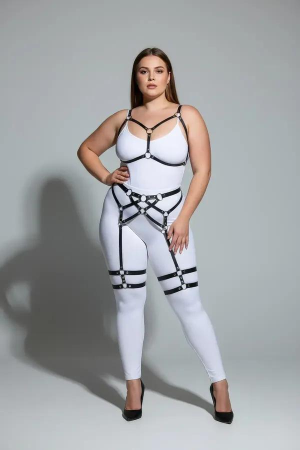 Black faux leather full body harness with chest V-frame, waist cage, and dual thigh garter bands on plus-size model