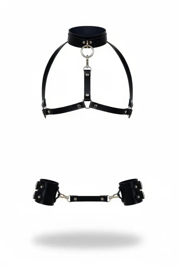 Black faux leather chest harness with silver O-ring collar and detachable wide wrist cuffs set on white background