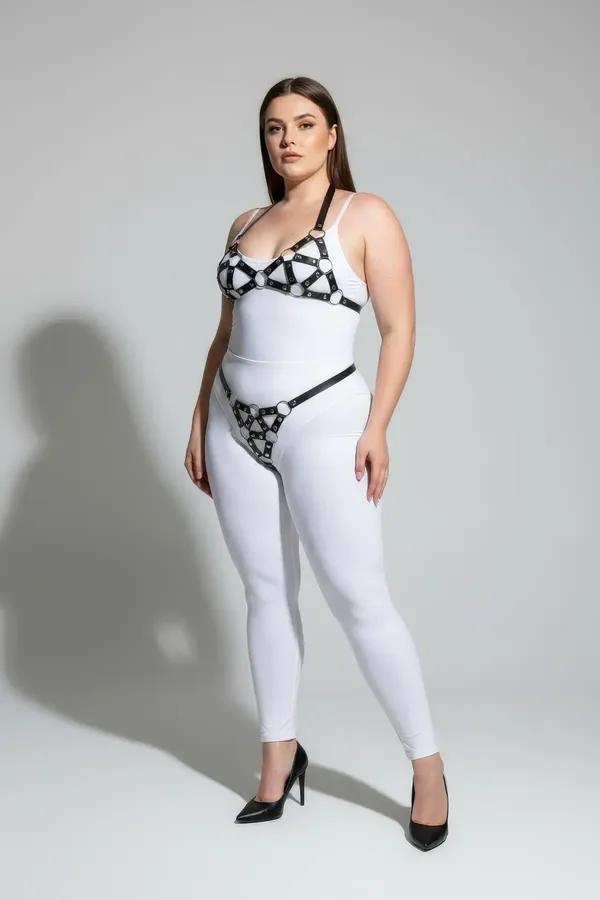 black faux leather cage harness bra and garter belt set with silver O-rings worn over white bodysuit