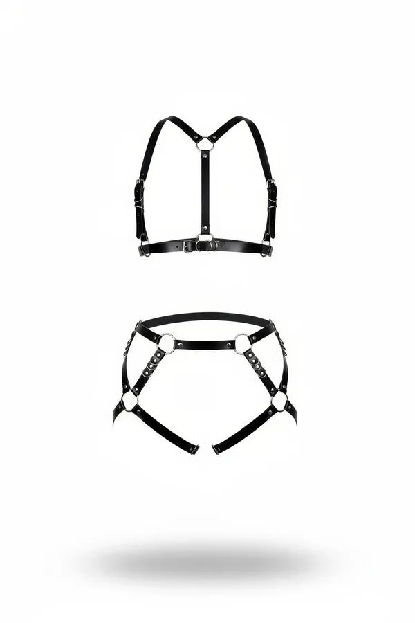 Black faux leather chest harness bra and garter belt set with silver O-rings and riveted strap detailing, laid flat on white