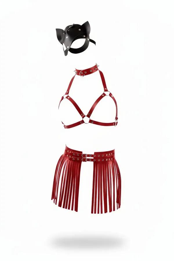 Three-piece red vegan leather harness set including a fringe waist belt, caged bra, spiked choker, and black cat mask flat lay.