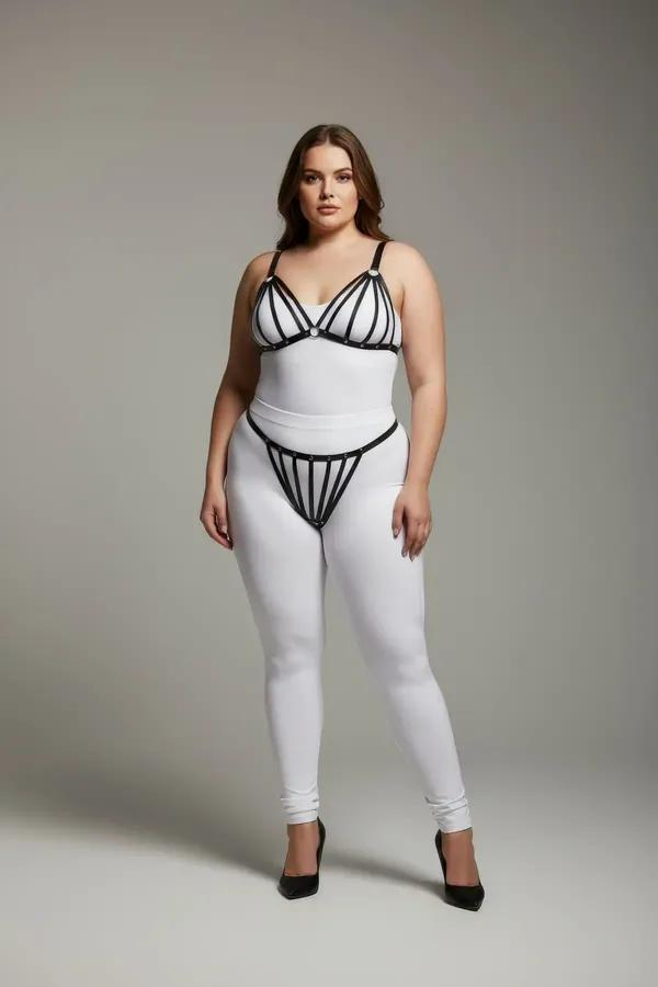 black faux leather strappy cage harness bra and thong set with silver stud hardware on plus-size model