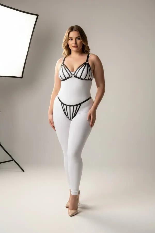 black faux leather strappy cage harness bra and thong set with silver stud hardware on plus-size model