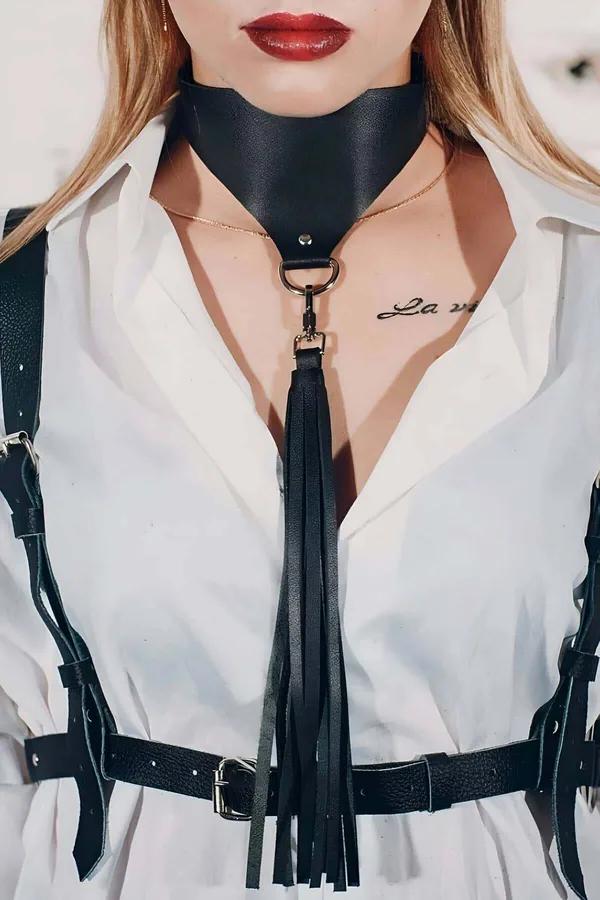 Püsküllü siyah vegan deri choker altın D-halka ve uzun siyah deri püskül beyaz gömlek üstünde