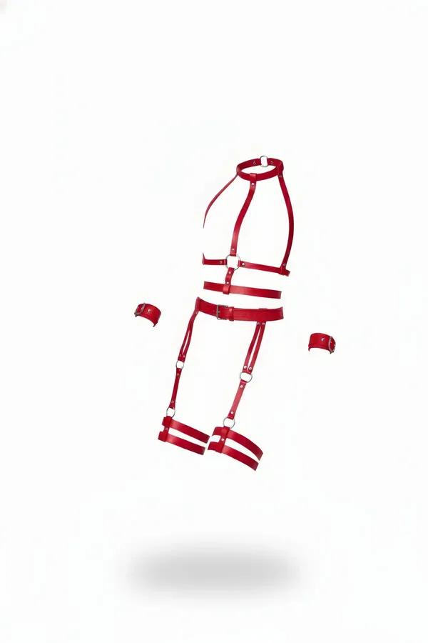 red vegan leather full body cage harness with double leg garters and wrist cuffs laid flat on white background