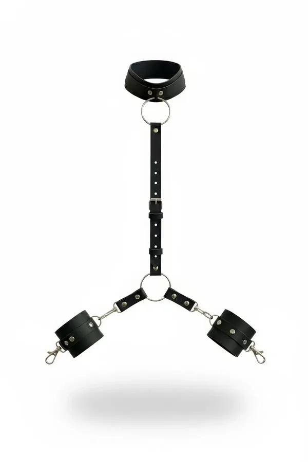 black faux leather collar and wrist cuffs body harness set with silver O-rings and snap hooks on white background