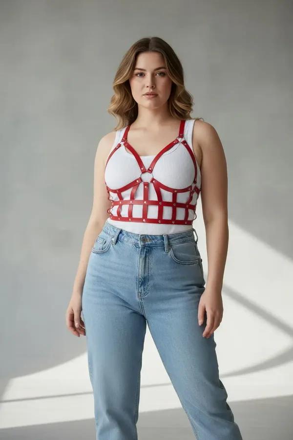 red faux leather caged bustier harness with grid strap pattern O-ring detail and silver rivets worn over white bra
