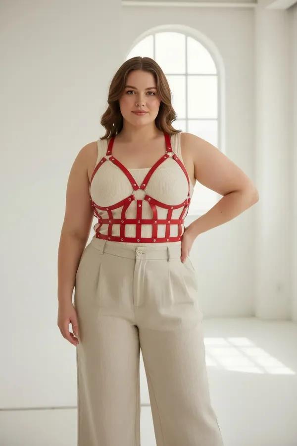 red faux leather caged bustier harness with grid strap pattern O-ring detail and silver rivets worn over white bra