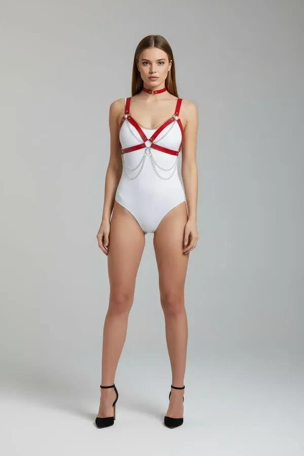 red faux leather body harness with draped silver chains and O-rings worn over white bodysuit with matching red choker