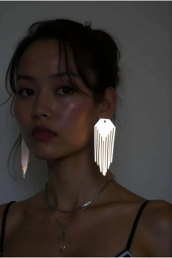 Silver mirror-finish reflective tassel earrings with geometric hexagonal cutout panel, 10 cm drop, worn as statement jewelry