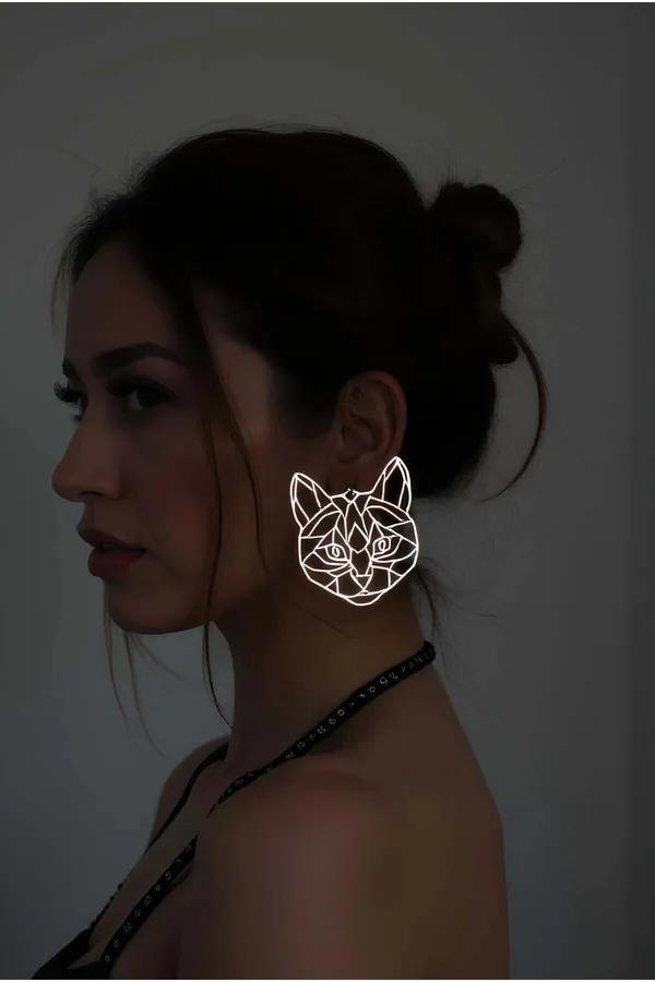Silver geometric cat face statement earrings with open wireframe angular line design reflecting light in low-light setting