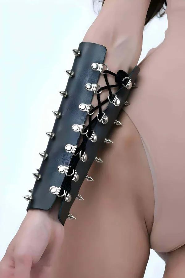 Black faux leather arm cuff gauntlet with silver cone spikes and D-ring lace-up closure on forearm