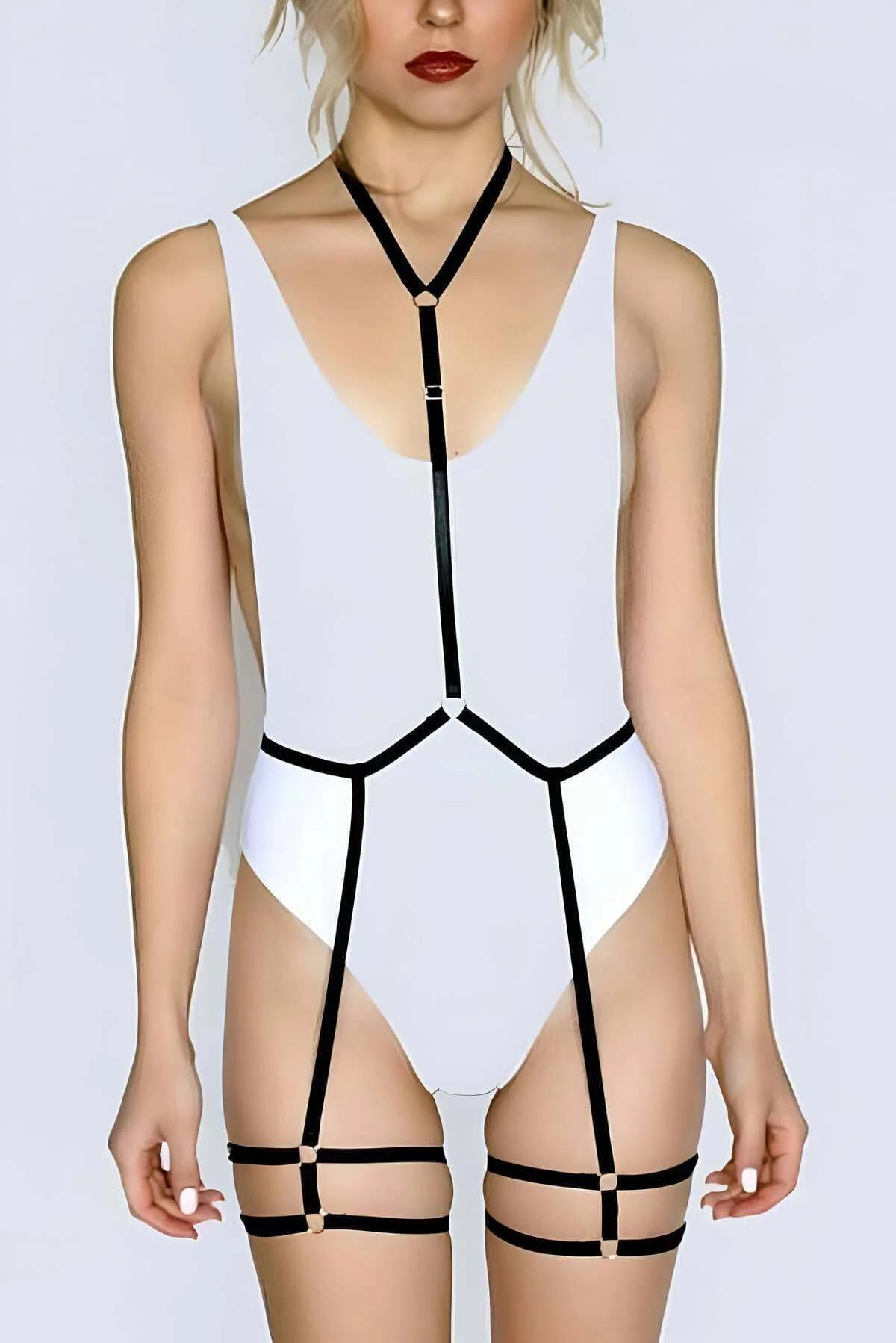black nylon elastic body harness set with gold O-rings worn over white bodysuit plus matching black leg garters on thighs