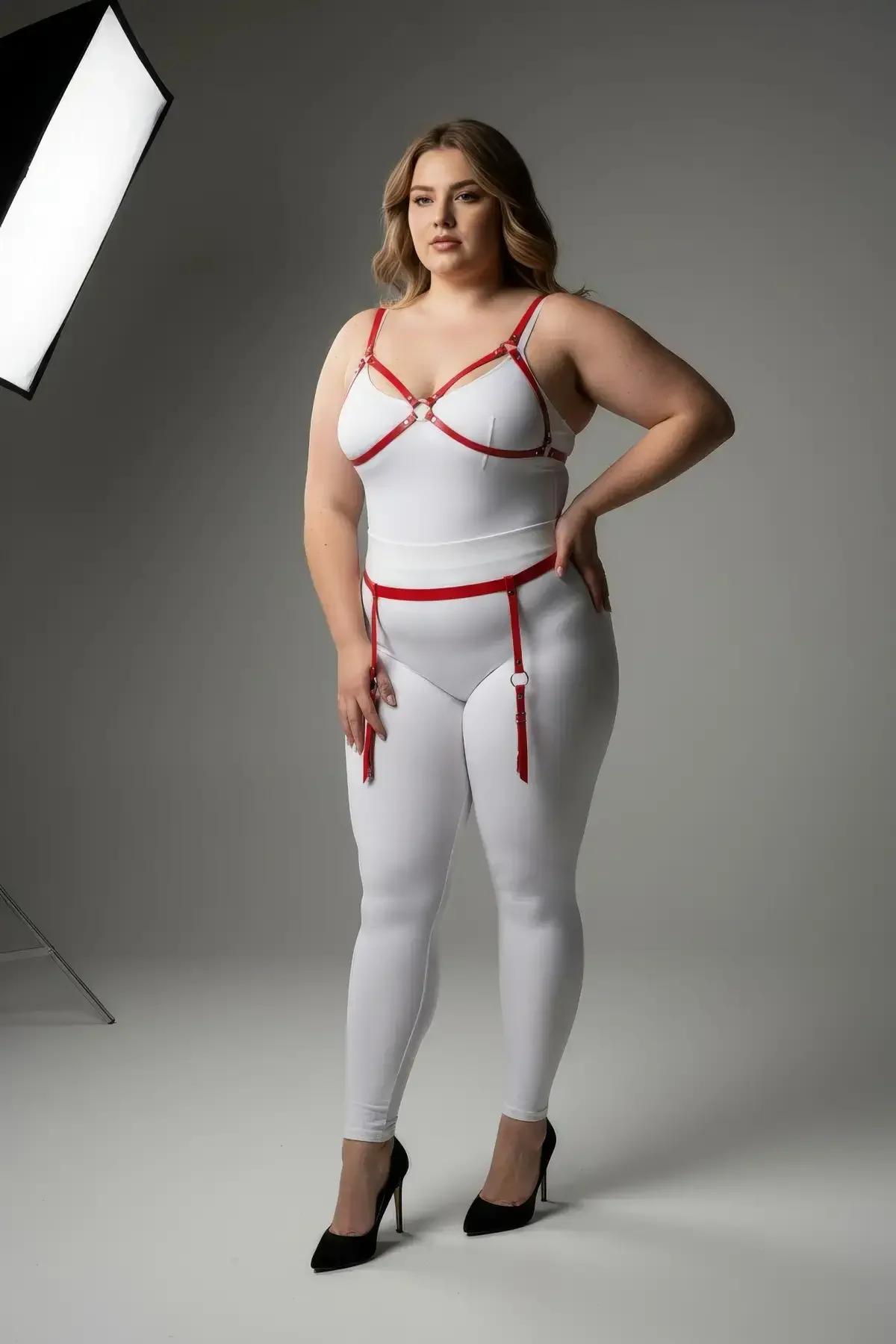 Red vegan leather strappy bra harness and thigh garter set with O-ring hardware and fringe tassel straps on plus-size model