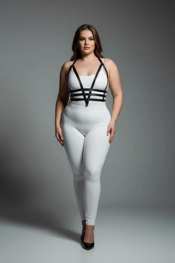 Black vegan leather strappy body harness with V-strap chest and three midriff bands worn over white outfit, silver rivet hard