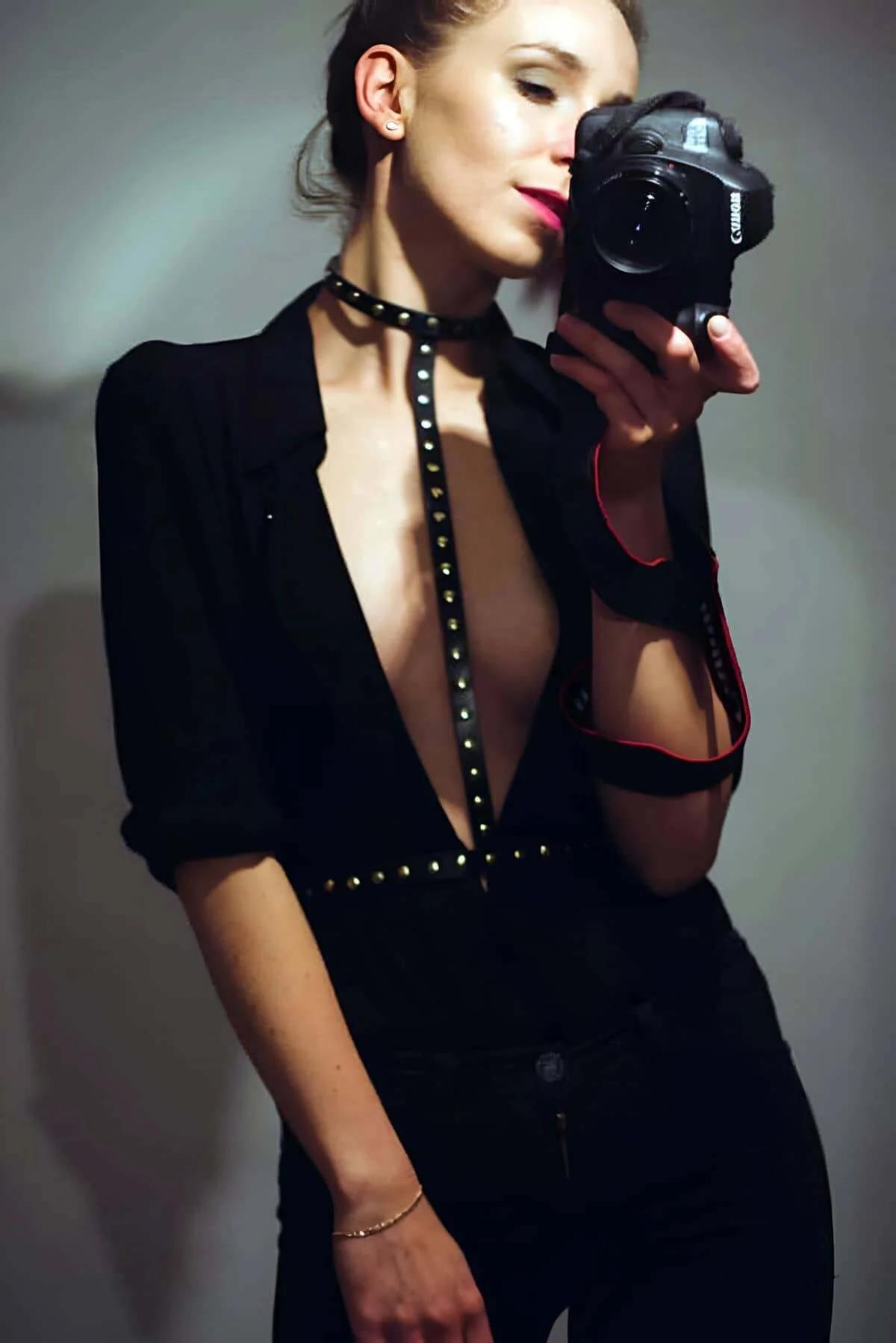 black faux leather studded body harness with gold rivets T-shape choker and waist strap worn over open blazer