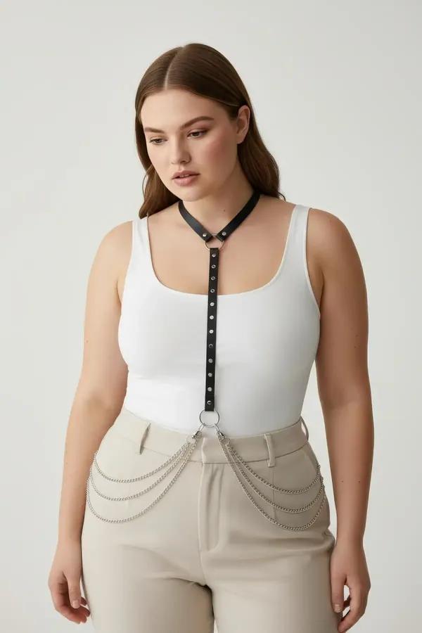 black faux leather rivet embellished harness with cascading silver hip chains worn over white tank top