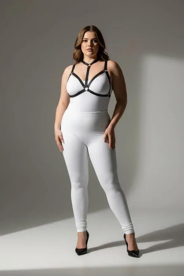 Black faux leather strappy o-ring chest harness worn over white bodysuit, silver buckle hardware, cage silhouette front view