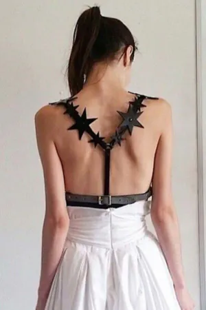 Black Faux Leather Star Back Harness with cutout straps and adjustable waist belt, worn over a white dress