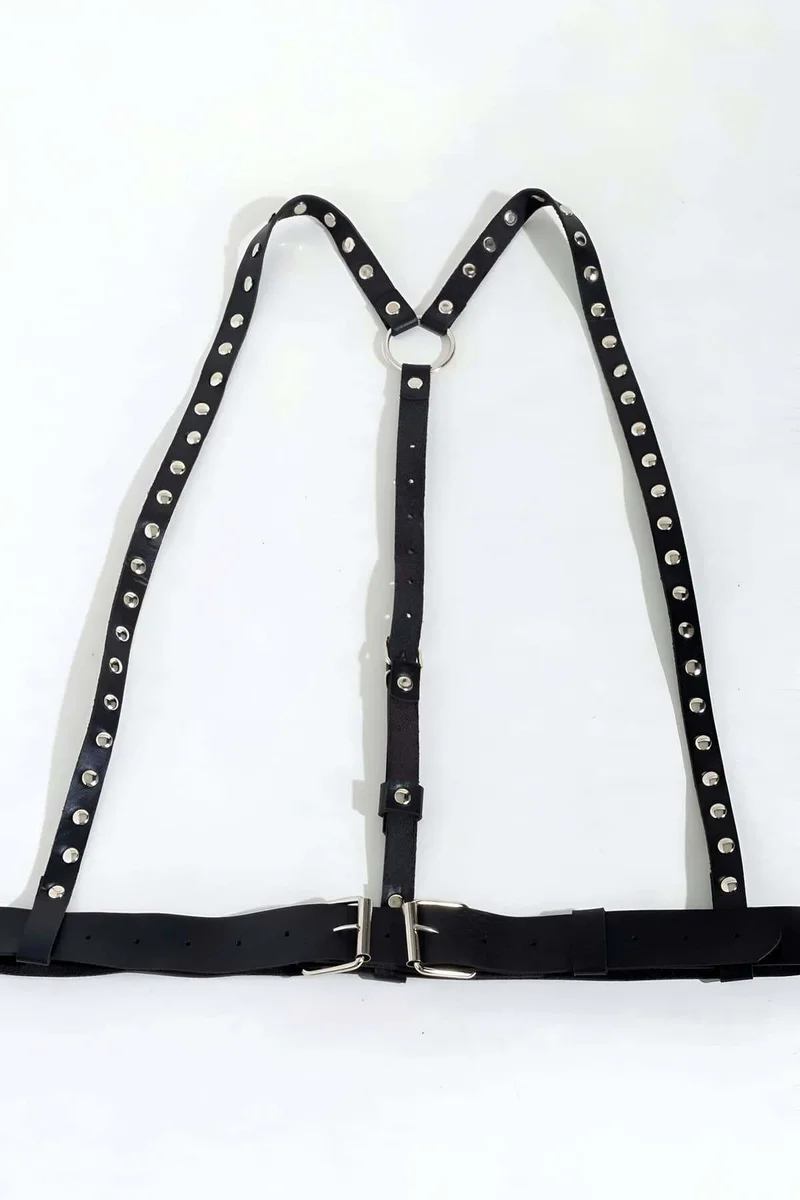 Studded shoulder harness detail showing silver studs and faux leather texture