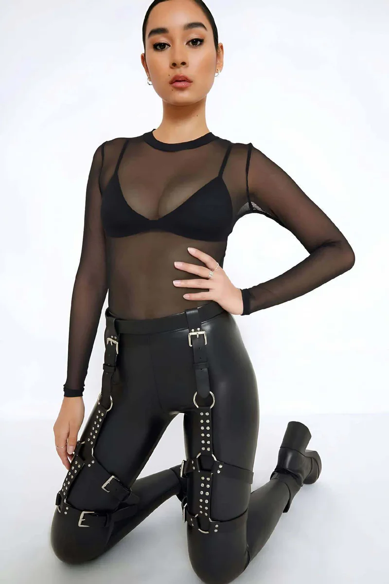 Black faux leather studded thigh harness with multiple buckles and rings on leggings