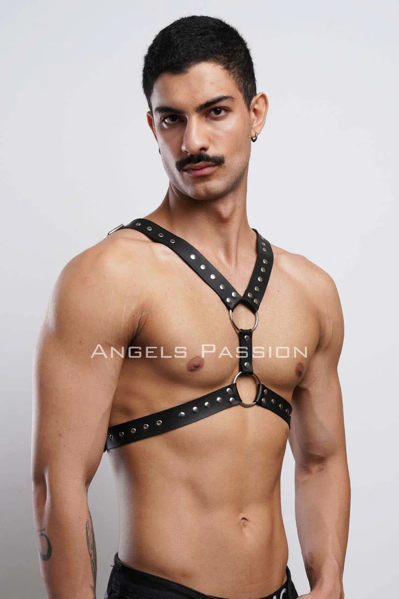 Black leather chest harness studded with metal o-ring details on torso