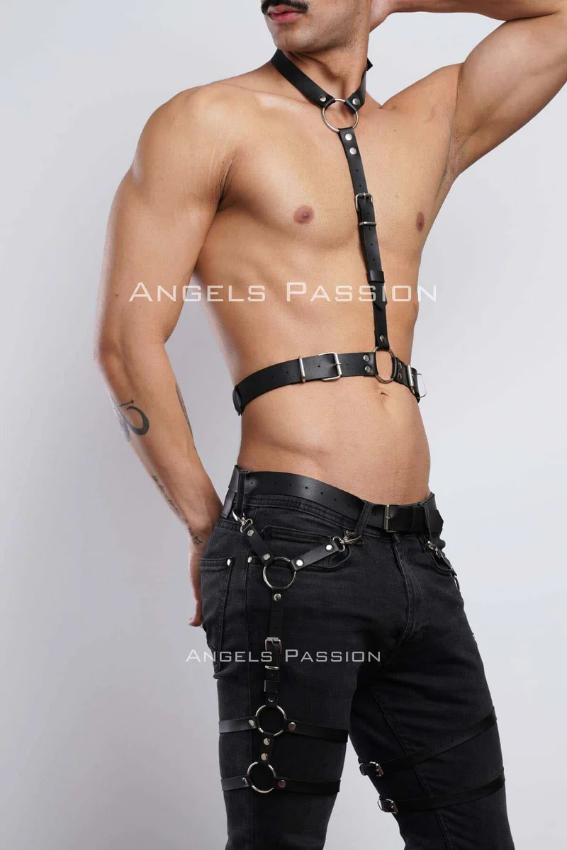Close-up of black faux leather chest harness straps and O-ring hardware with leg garter rings.