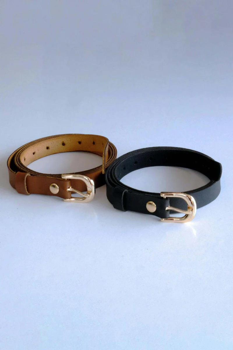 Close-up of the buckle detail on a black faux leather belt with hardware