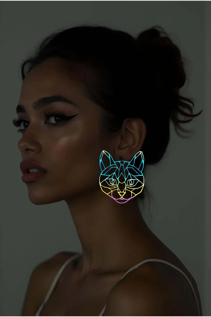 Reflective Geometric Cat Earrings rainbow iridescent effect worn by model in low light, glowing outline profile