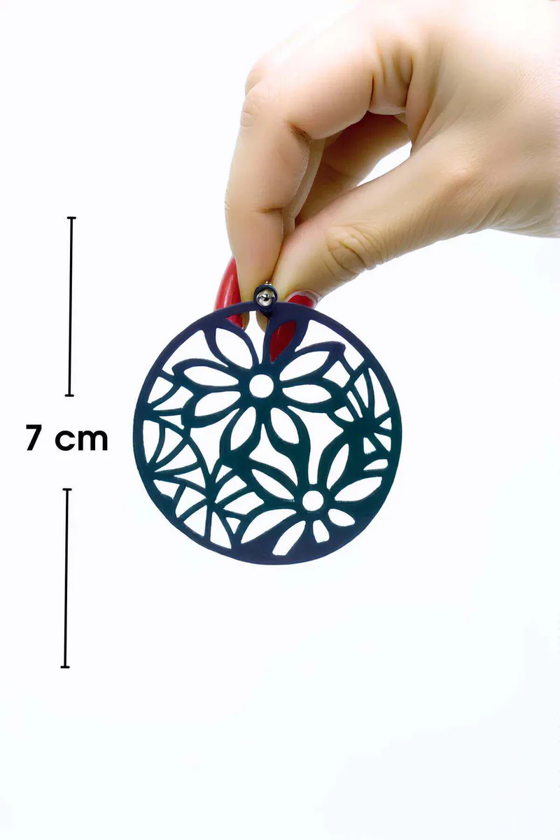 UV reactive dark blue floral earring held