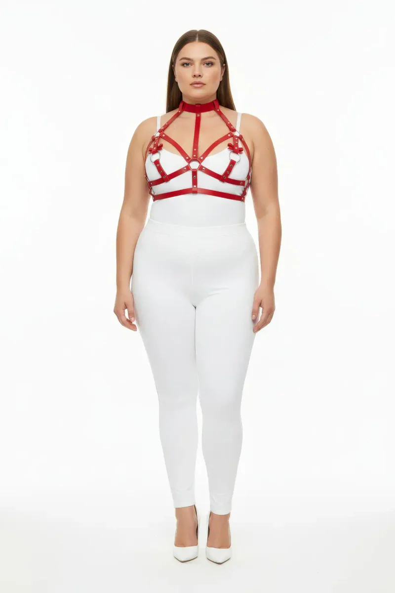 Red faux leather chest harness close-up showing O-ring detail and intricate strapping