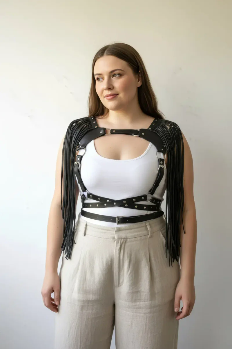 Plus size model wearing black fringe harness over